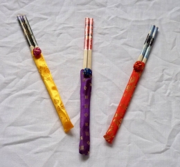Pár barevných jídelních hůlek v hedvábném pouzdře